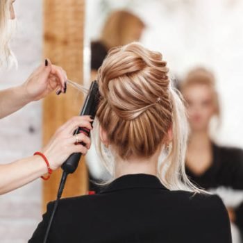 business woman lady boss in beauty salon making hairdress and looking to the mirror